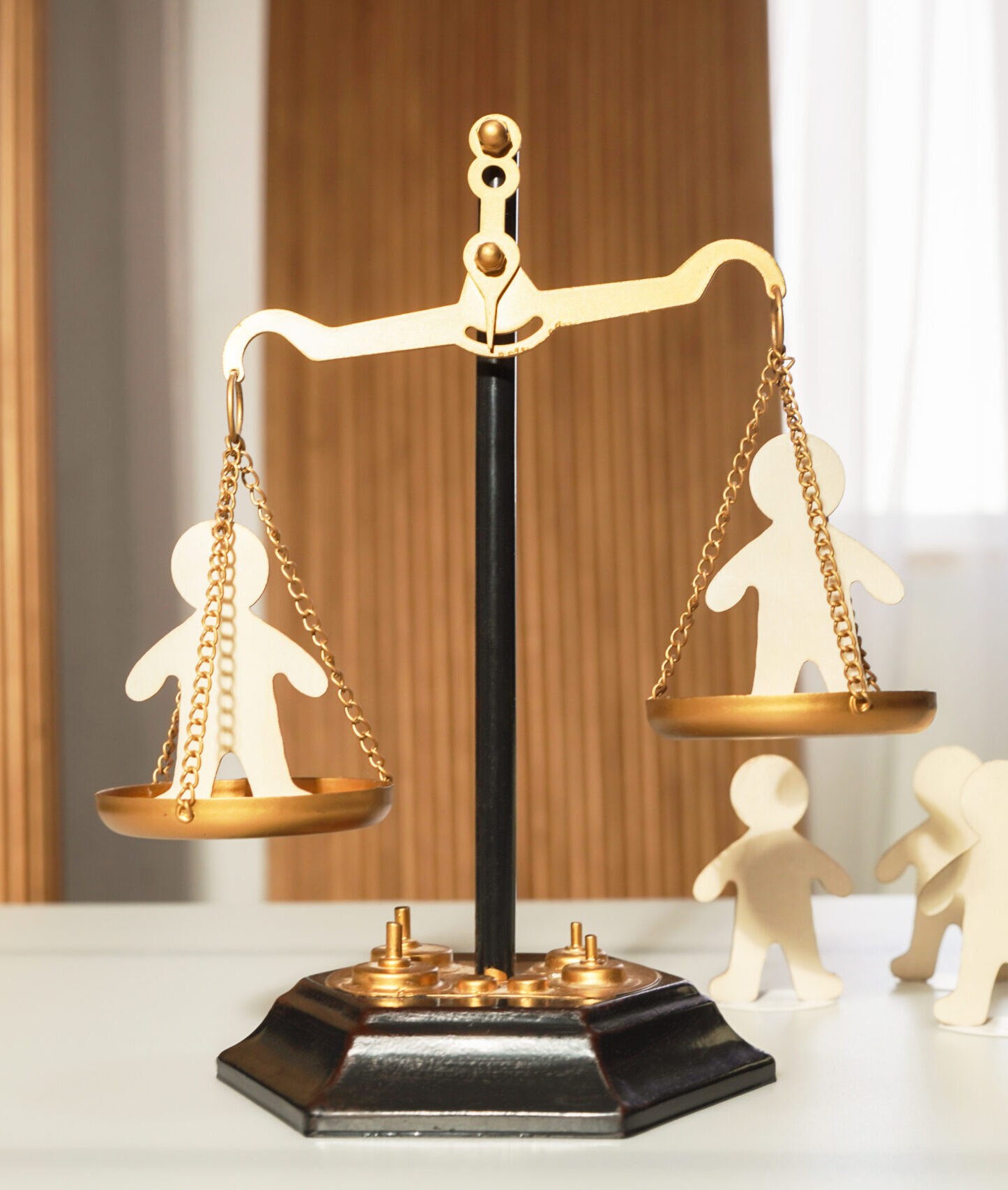 On the judge's scales, there are figures of people in each bowl, with a waiting